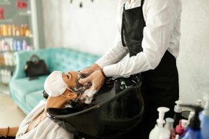 young-woman-with-protective-face-mask-enjoying-hair-wash-hairdresser-s